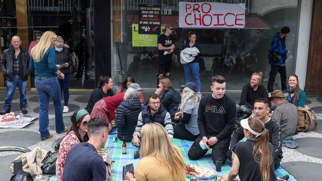 Protesters sat out the front of a shop in St Kilda on Saturday. Picture: NCA NewsWire / Ian Currie