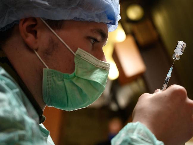 A Swiss soldier fills up a syringe with Pfizer. Picture: AFP