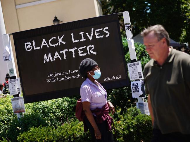 People walk past a "Black Lives Matter" message on a sign near a Washington DC church. Picture: AFP