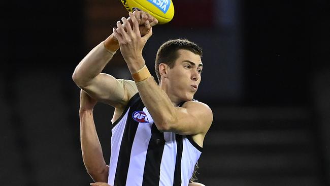 MELBOURNE, AUSTRALIA - MARCH 20: Mason Cox of the Magpies handballs whilst being tackled during the round 1 AFL match between the Western Bulldogs and the Collingwood Magpies at Marvel Stadium on March 20, 2020 in Melbourne, Australia. (Photo by Quinn Rooney/Getty Images)