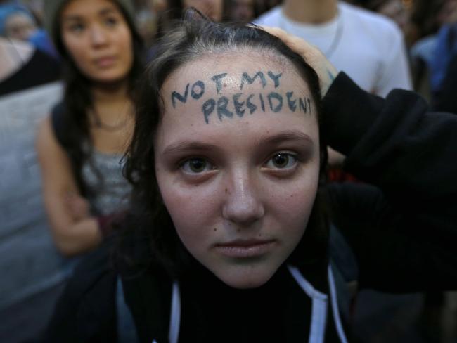 A protestor has the words “Not My President” written on her forehead as she takes part in a protest against the election of President-elect Donald Trump on November 9, 2016, in downtown Seattle. Picture: AP