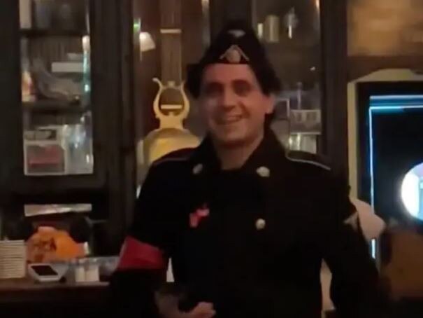 In the clip, the smiling young man, donning full regalia including a swastika armband, sidled up to the bar at Fanelli Cafe, leaving other patrons aghast. Source: @mattxiv