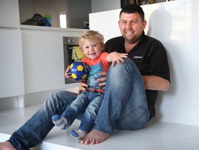 Mark Bulman, of Fairfield, pictured last year with his then two-year-old son Nate. Mark was chasing Nate in April 2015 when he kicked his foot against a Fantastic Furniture Worx chair. Part of his middle left toe was chopped off. Picture: Richard Dobson