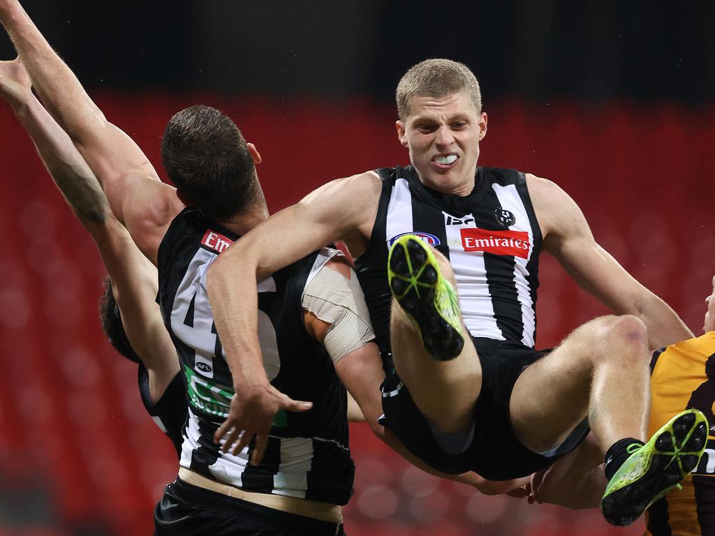 Collingwood's Will Kelly flies high but injures his arm.