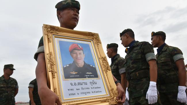 A Royal Thai Navy soldier with a portrait of Saman Gunan, the former navy SEAL who died in Tham Luang cave rescue mission. (Pic: Panumas Sanguanwong/AFP)