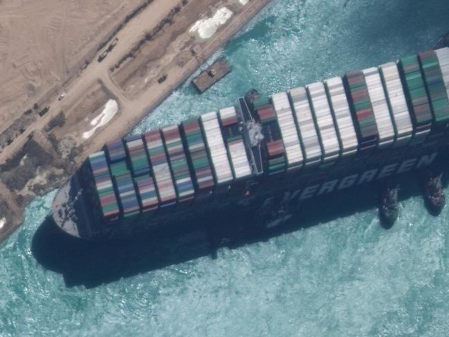 TOPSHOT - This satellite imagery released by Maxar Technologies shows a close up overview of the MV Ever Given container ship and tugboats in the Suez Canal on March 29, 2021. - The MV Ever Given was refloated and the Suez Canal reopened on March 29, 2021, sparking relief almost a week after the huge container ship got stuck during a sandstorm and blocked a major artery for global trade. AFP correspondents observed tugboat crews sounding their foghorns in celebration after the Ever Given, a cargo megaship the length of four football fields, was dislodged from the banks of the Suez. (Photo by - / Satellite image Â©2021 Maxar Technologies / AFP) / RESTRICTED TO EDITORIAL USE - MANDATORY CREDIT "AFP PHOTO / Satellite image Â©2021 Maxar Technologies" - NO MARKETING - NO ADVERTISING CAMPAIGNS - DISTRIBUTED AS A SERVICE TO CLIENTS