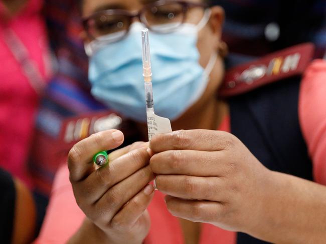 A healthcare worker holds the Johnson &amp; Johnson vaccine before administaring it to another healthcare worker at the Steve Biko Academic Hospital in Pretoria, South Africa. Picture: AFP