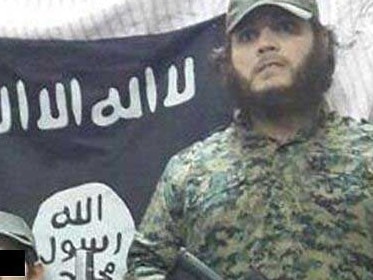 Islamic terrorist Khaled Sharrouf in front of the Islamic State flag.
