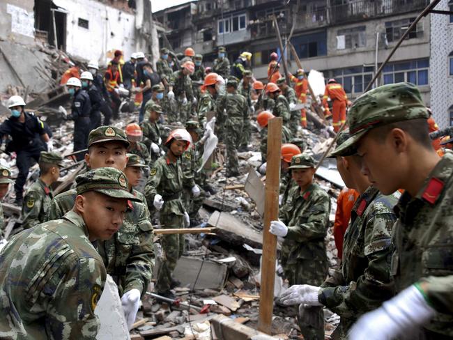 Rescuers clear the debris to search for victims on the site of the collapsed residential buildings. Picture: AP.