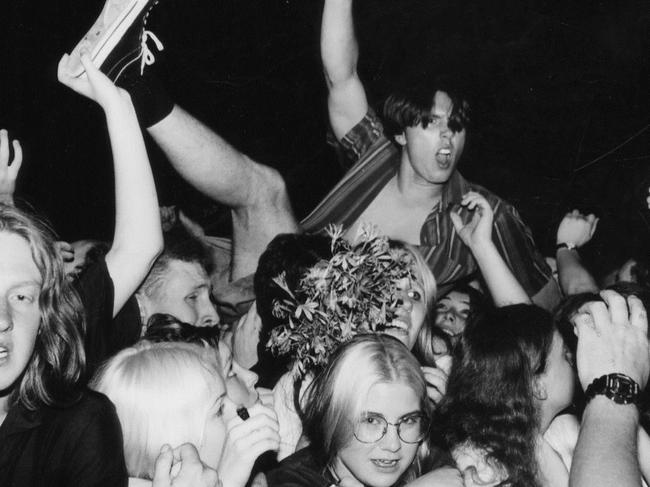 A boy crowd surfs over teenagers packed into the Adelaide Entertainment Centre to watch USA band Foo Fighters, during Summersault rock festival, 05 Jan 1996.
