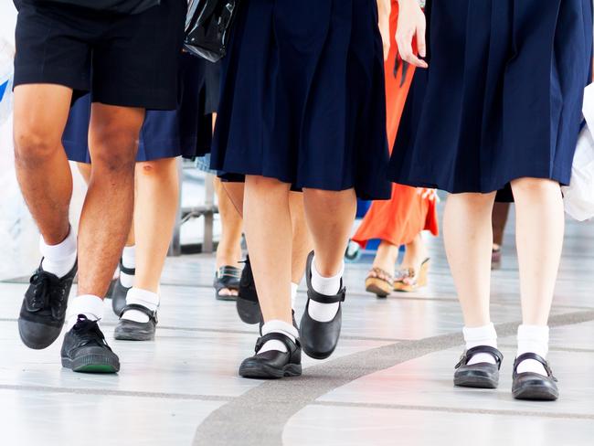 Capture of feet and shoes of students in school uniform and leaving shopping mall and walking over pedestrian bridge.