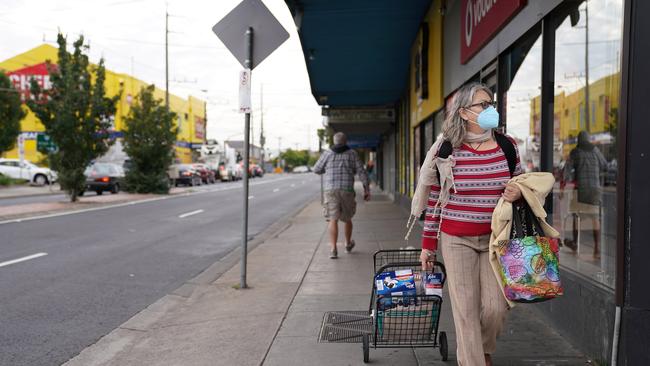 A member of the public is seen walking home from the shops in Preston, Melbourne. (AAP Image/Stefan Postles)