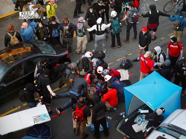 Medics tend to a man who was shot in the arm by a driver of a black vehicle at a protest against racial inequality. Picture: Reuters