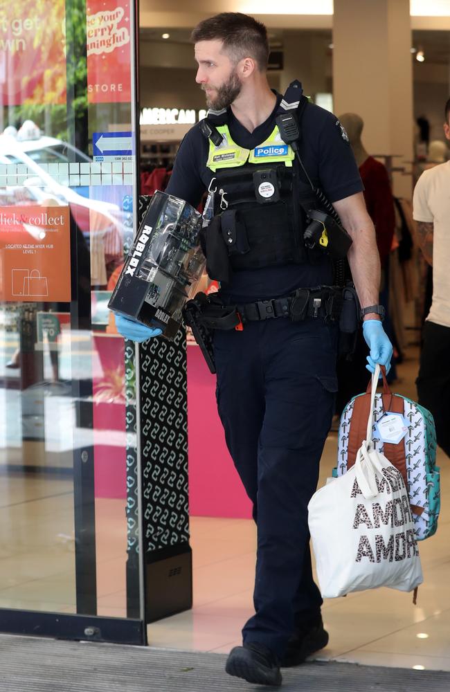 Police carrying items alleged to have been shoplifted. Picture: Alan Barber