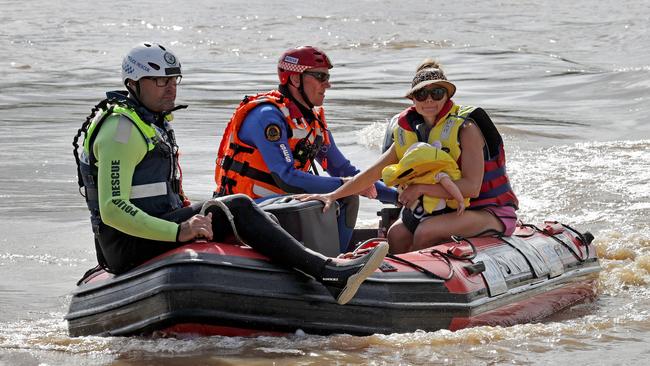 Members of the SES evacuate a woman and her daughter from their home on Palmers Island. Picture: Toby Zerna