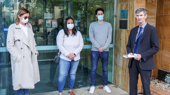 Detective Acting Senior Sergeant Graham Ross (right) with the victims of the attack outside of Box Hill Police Station. Picture: Tim Carrafa