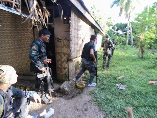 Police and soldiers take position as they engage with the Abu Sayyaf group in the village of Napo in Inabanga town, Bolo province, in the central Philippines on April 11. Picture: STR