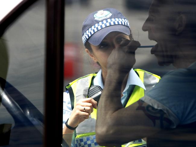 A police officer performs a road side random drug test. Police from the Kings Cross Local Area Command perform random breath tests and drug tests along Cowper Wharf Road, Woolloomooloo. GEneric, police, RBT, random breath test, alcohol, drink driving