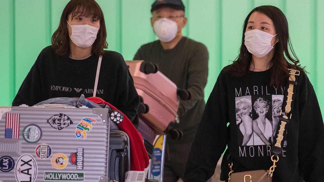 Passengers wear face masks to protect against the COVID-19 (coronavirus). Picture: Mark RALSTON / AFP.