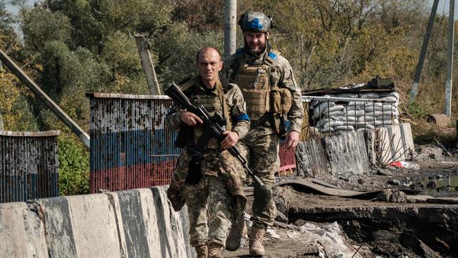 Ukrainian servicemen cross the destroyed bridge over the Oskil River in Kupiansk, in the Kharvik region on Thursday. Picture: AFP