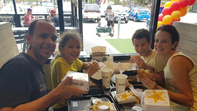 Nathan, Lydia, Hayden and Michelle Young enjoying their free Carl's Jr burgers at Rothwell. Photo Erin Smith. 