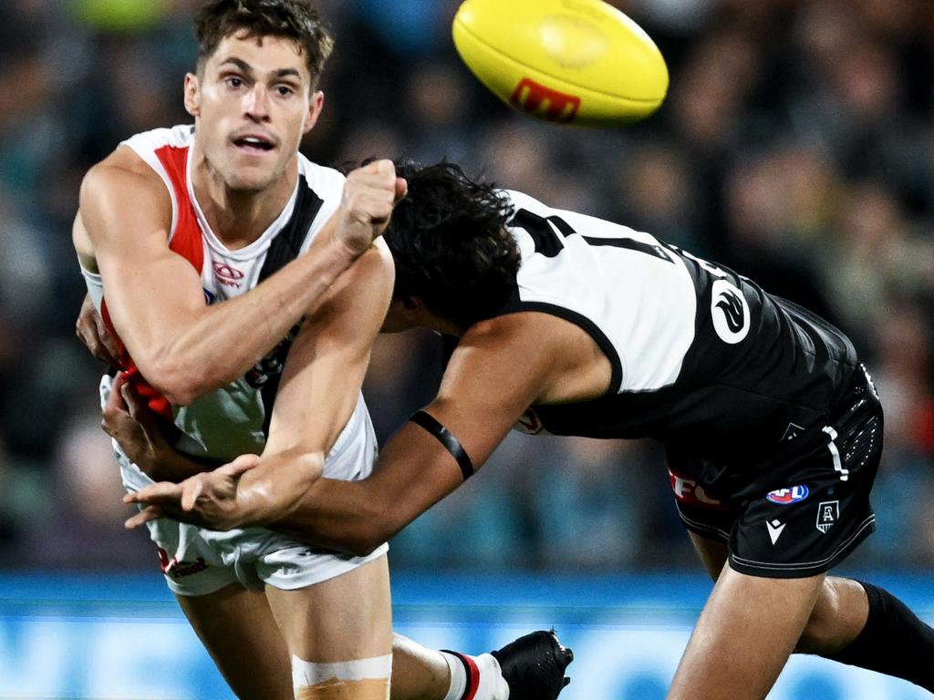 Jack Steele of the Saints handballs tackled by Jase Burgoyne of the Power during the round seven AFL match . (Photo by Mark Brake/Getty Images)