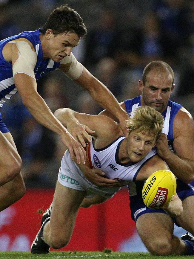 Rory Sloane fights for the loose ball under pressure from Luke Davies-Uniacke (left) and Ben Cunnington of the Kangaroos. Picture: AAP Image/Hamish Blair