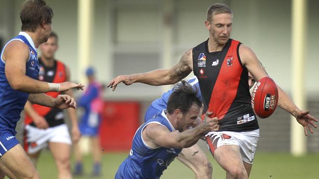 Tea Tree Gully's Jack Astbury tries to clear under pressure from St Peter’s Old Collegians’ Sam Stott during a division one Adelaide Footy League match last year. Picture: AAP/Dean Martin