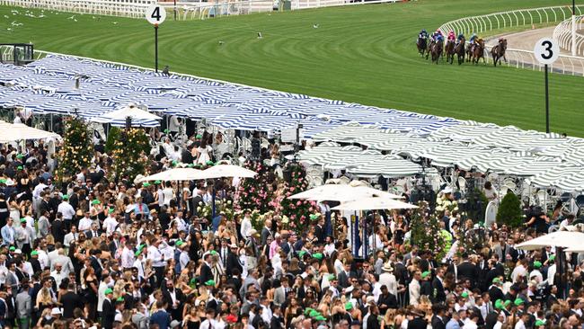 A massive crowd watches the Victoria Derby field turn for home today Picture: Quinn Rooney/Getty Images)