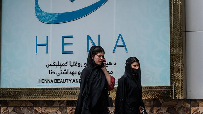 Women walk past a beauty salon in Kabul on Tuesday. Picture: AFP