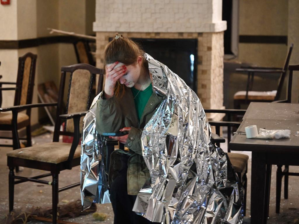 A member of staff in Kharkiv shelters under a security blanket after a missile strike during the ongoing Russian invasion of Ukraine. Picture: Sergey Bobok/AFP