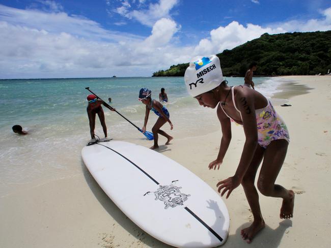 FILE - In this June 13, 2009 file photo, children play at a resort beach in Ngerkebesang, Palau. In an attempt to protect the coral reefs that divers so admire they have dubbed them the underwater Serengeti, the Pacific nation of Palau will soon ban many types of sunscreen. President Tommy Remengesau Jr. Oct. 25, 2018, signed legislation that bans "reef-toxic" sunscreen from 2020. Banned sunscreens will be confiscated from tourists who carry them into the country, and merchants selling the banned products will be fined up to $1,000. (AP Photo/Itsuo Inouye, File)