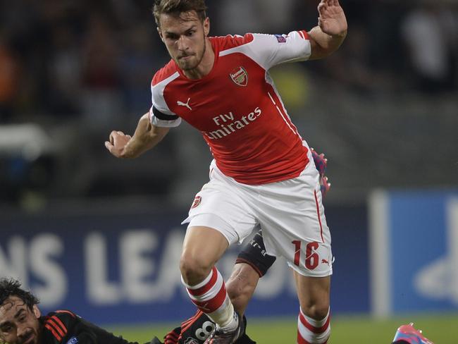 Arsenal's Aaron Ramsey (R) vies with Besiktas' Veli Kavlak (L) during the UEFA Champions League play-off first leg football match Besiktas vs Arsenal at the Ataturk Olympic Stadium in Istanbul, on August 19, 2014. AFP PHOTO/BULENT KILIC