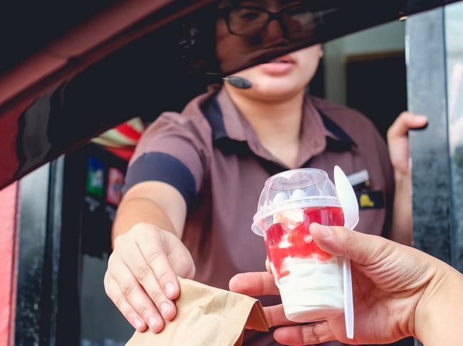 Bangkok, Thailand - Mar 4, 2017: Unidentified customer receiving hamburger and ice cream after order and buy it from McDonald's drive thru service, McDonald's is an American fast food restaurant chain