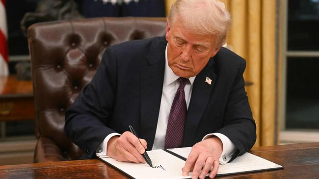 US President Donald Trump signs an executive order in the Oval Office of the WHite House in Washington, DC, on January 20, 2025. (Photo by Jim WATSON / POOL / AFP)