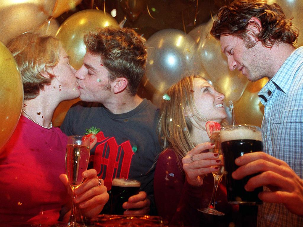 Angela Brown (L) kisses Christian Munn while Jackie Nasser talks with Julian Cornall as they celebrate NYE Millennium at Southgate December 31, 1999. Picture: James Croucher.