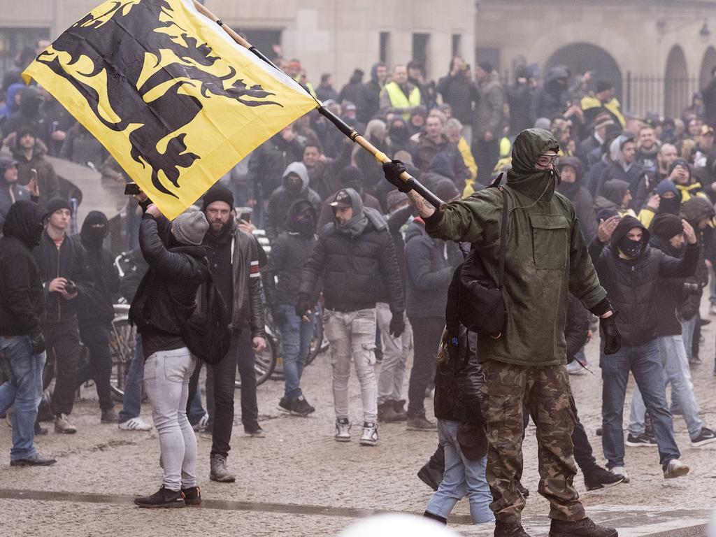 A protester waves a Flemish flag at the police during an anti-migrant demonstration outside of EU headquarters in Brussels. Picture: AP