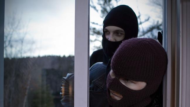 Generic picture of two masked burglars entering house through glass sliding door.