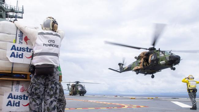 An Australian Army MRH-90 Taipan launches from the flight deck of HMAS Adelaide to drop disaster relief supplies to Nabouwalu on the island of Vanua Levu, Fiji, during Operation Fiji Assist. PICTURE: Dept of Defence.