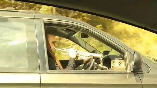 A man pictured playing the trumpet while driving down the M1 (Pacific Motorway) on the Gold Coast, Wednesday November 14, 2018