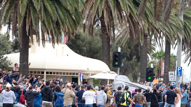 A ute passing by with an anti-racist chant playing is surrounded by opposing far-Right protesters. Picture: Sarah Matray