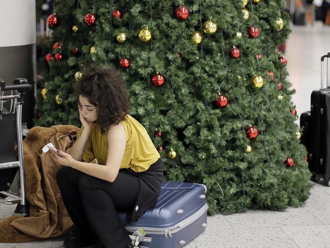 A woman waits in the departures area at Gatwick Airport, near London, as the airport remains closed after drones were spotted over the airfield. Picture: AP Photo/Tim Ireland