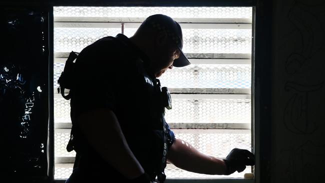 An unrelated photo of a Corrective Services officer checking the seal on a window for contraband during a raid on cells at Silverwater Jail. Picture: Richard Dobson