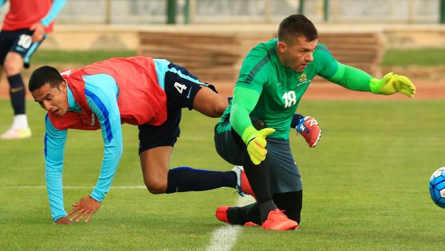 Danny Vukovic makes life hard for Tim Cahill in training in Tehran.