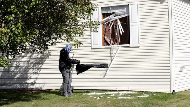 A person cleans up debris from a broken window at a home FBI agents searched in Hartland Township mobile home park in connection of a plot to kidnap Michigan Governor Gretchen Whitmer. Picture: Jeff Kowalsky/AFP