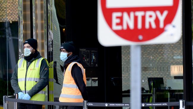 Security at Crown Promenade as people leave the hotel after two weeks of enforced quarantine. Picture: Andrew Henshaw