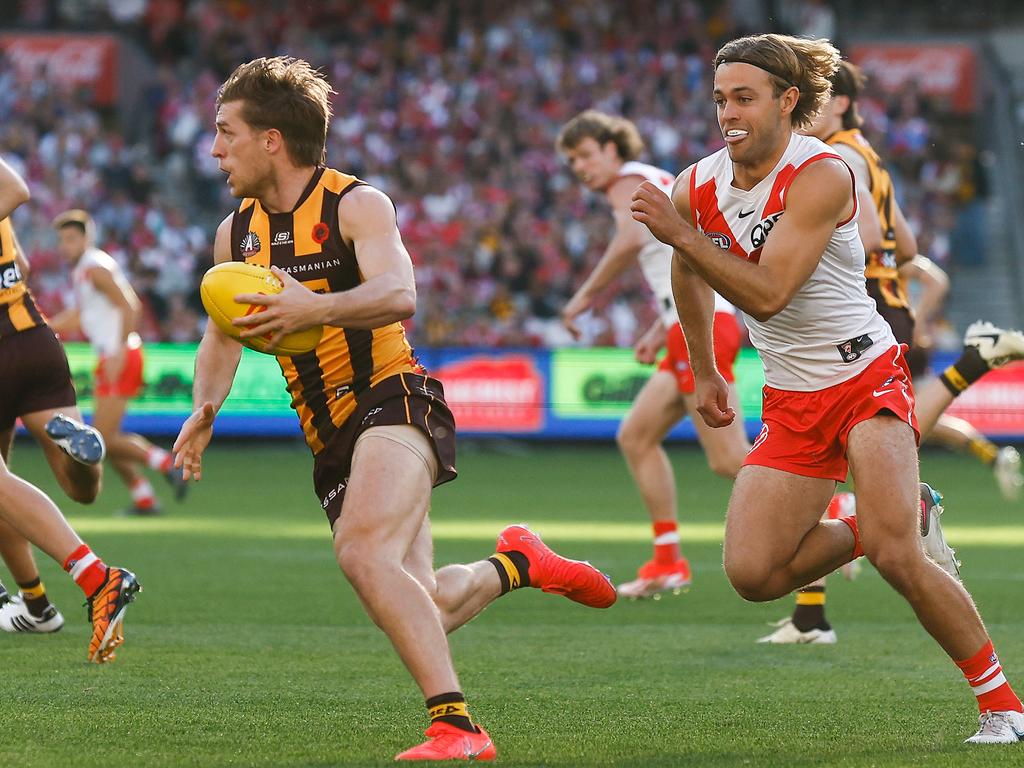 MELBOURNE, AUSTRALIA - APRIL 28: Dylan Moore of the Hawks is chased by James Rowbottom of the Swans during the 2024 AFL Round 07 match between the Hawthorn Hawks and the Sydney Swans at the Melbourne Cricket Ground on April 28, 2024 in Melbourne, Australia. (Photo by Michael Willson/AFL Photos via Getty Images)