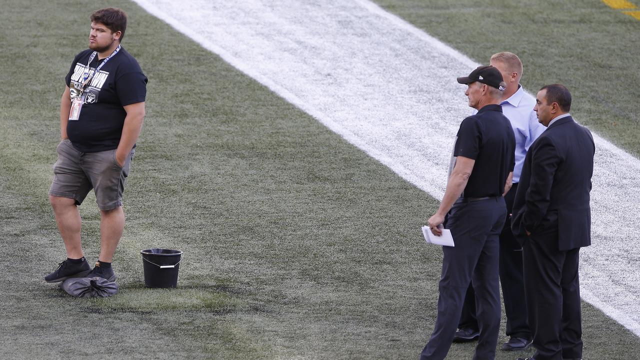 Officials assess the location where the CFL goalpost holes were.