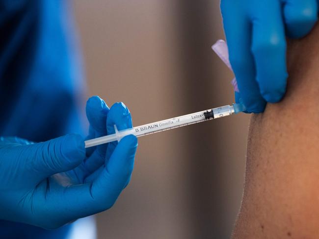 A health worker vaccinates an elderly person with the Biontech-Pfizer Covid-19 vaccine at a temporary vaccination clinic in a church in Sollentuna, north of Stockholm on March 2, 2021. (Photo by Fredrik SANDBERG / TT News Agency / AFP) / Sweden OUT