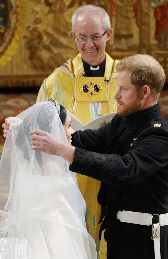 Prince Harry pulls back Meghan’s veil as the Archbishop of Canterbury Justin Welby looks on. Picture: Owen Humphreys/AP